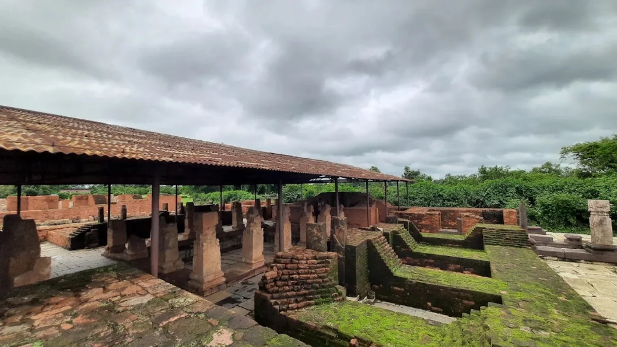 Excavated ancient stone and brick Buddhist monastery ruins at Sirpur archaeological landscape in Chhattisgarh under overcast sky